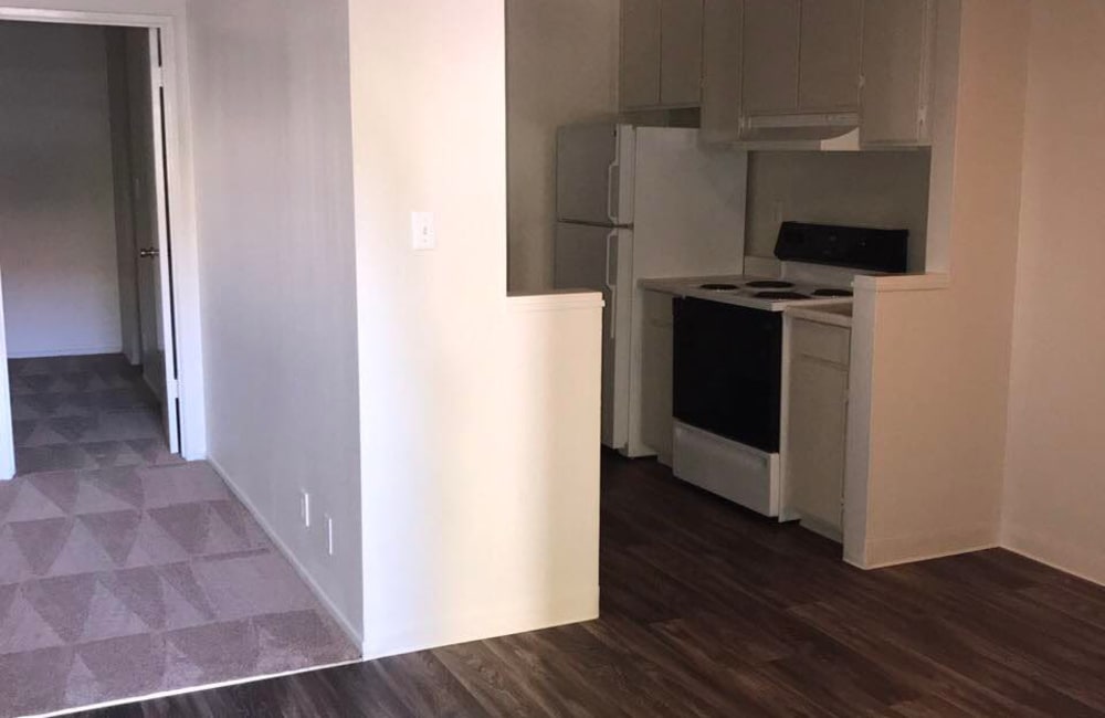 View to the kitchen and bedrooms from the living room in a model home at Parkway Green in Union City, California
