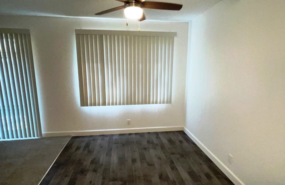 Hardwood floor dining table area with ceiling fan and large windows in a model home at Parkway Green in Union City, California
