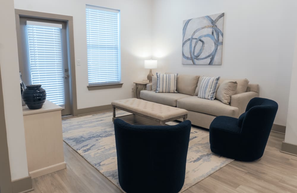 Model living space with wall art and couch at The Waters at Heritage in Gonzales, Louisiana