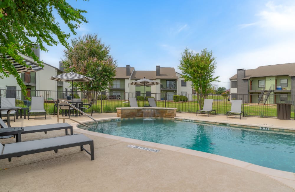 Poolside seating at Leander Apartment Homes in Benbrook, Texas