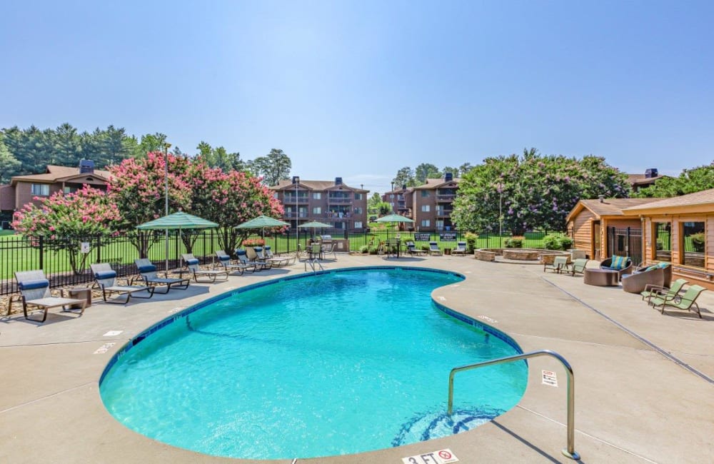 Outdoor swimming pool area at Riverwind Apartment Homes in Spartanburg, South Carolina