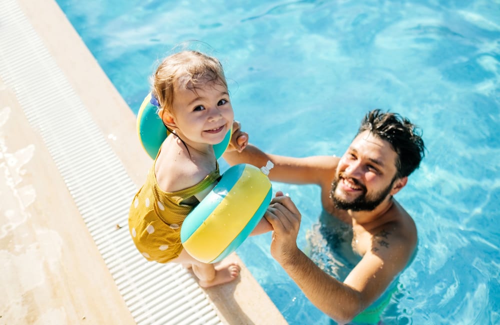 Happy father with his kid in swimming pool at Foothill Courtyard Apartments in Vista, California
