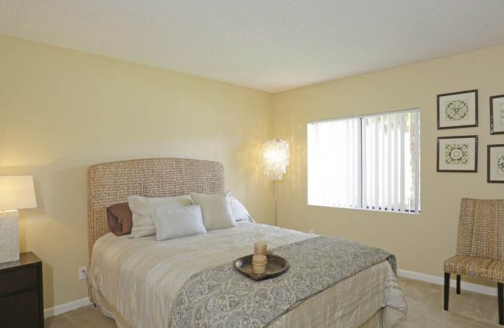  Spacious Bedroom with comfortable large bed, chair, and wall pictures at Countryside Apartments in Poway, California