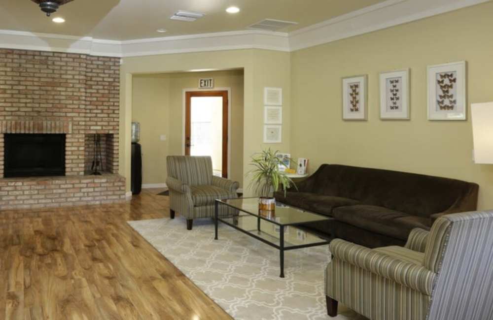 Cozy living room with brick fireplace and comfortable couches at Countryside Apartments in Poway, California