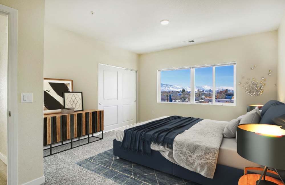 A Well-lit comfortable bedroom with bed and large window at The Atrium at Victorian Square in Sparks, Nevada