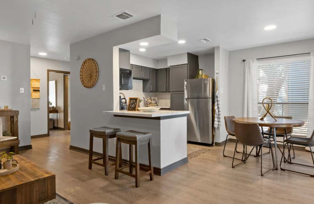 Living room with attached kitchen, dining area and wooden flooring at Hill At Woodway in San Antonio, Texas