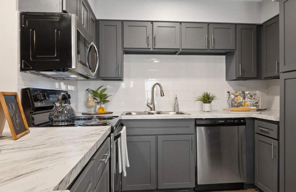 Kitchen with granite countertop, wooden cabinets at Hill At Woodway in San Antonio, Texas