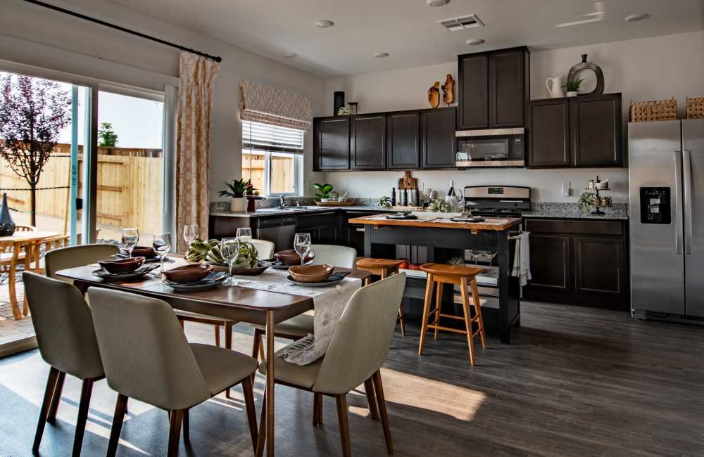 A furnished home dining room and kitchen with a sliding door to the backyard at Aspen Vista at Anchor Pointe in Reno, Nevada