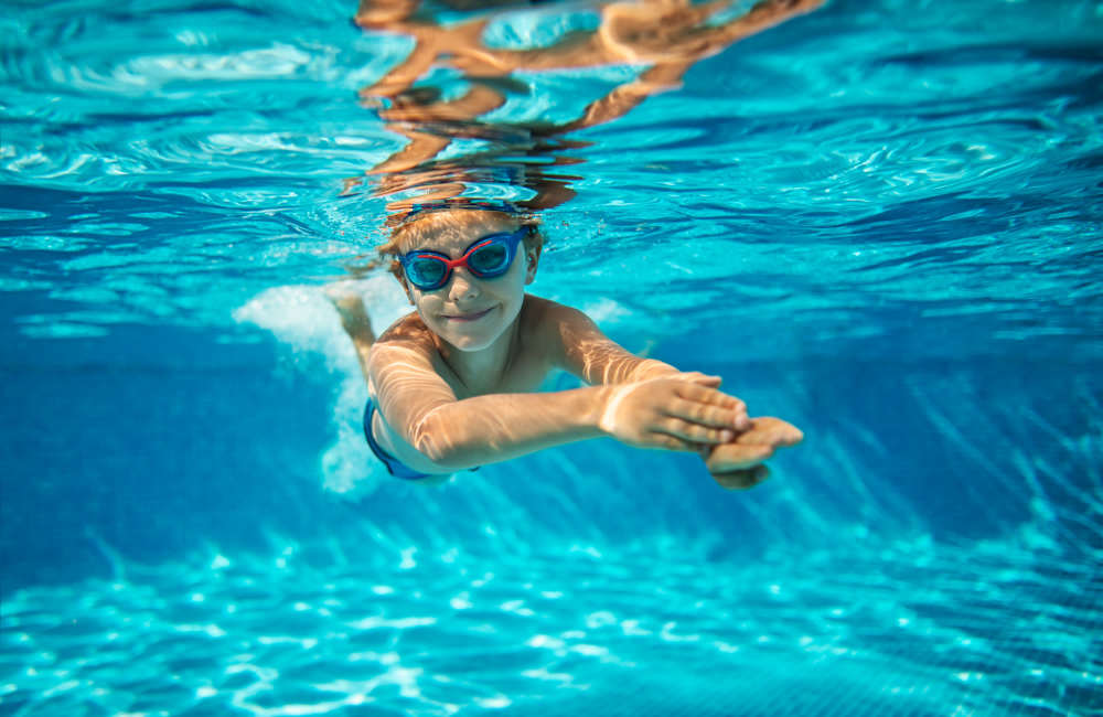 Resident under the water in the swimming pool at Reidy Creek Apartments in Escondido, California