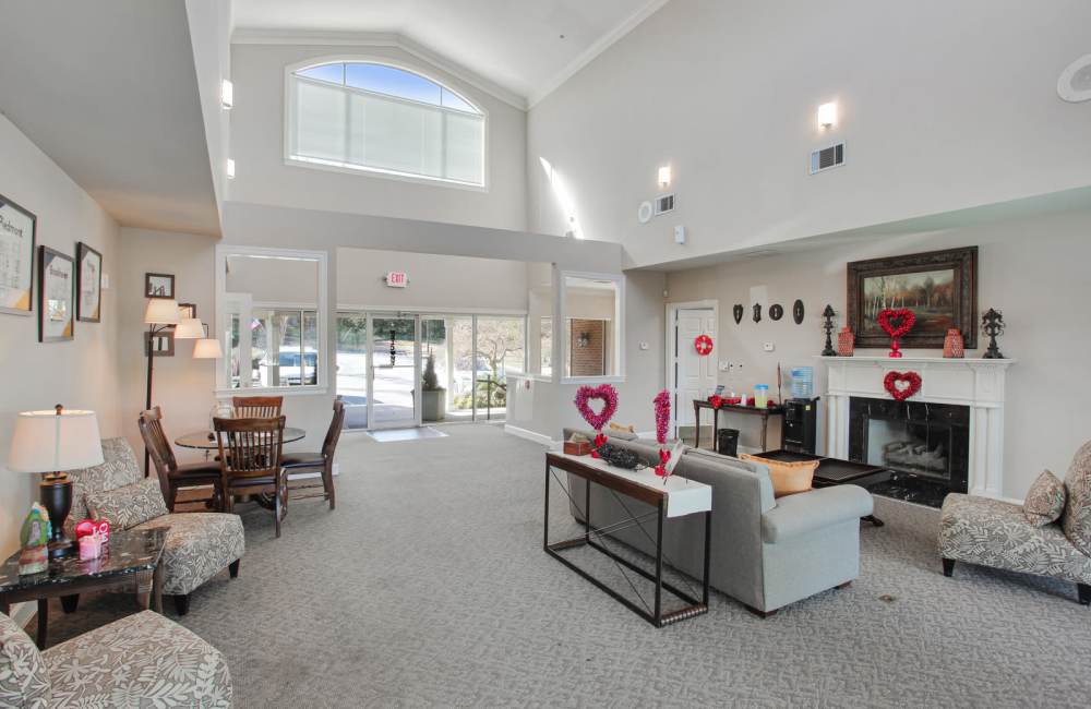 Resident lounge with fireplace and seating at Wellington Point in Atlanta, Georgia