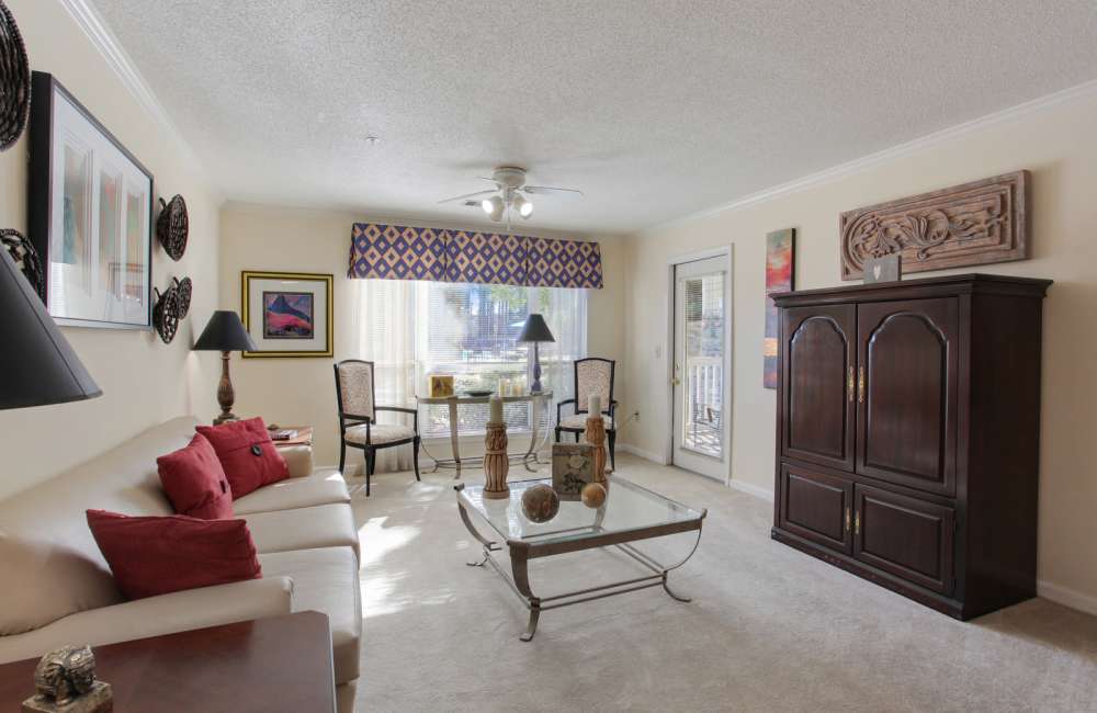 Sunlit apartment living room with leather sofa and coffee table at Wellington Point in Atlanta, Georgia