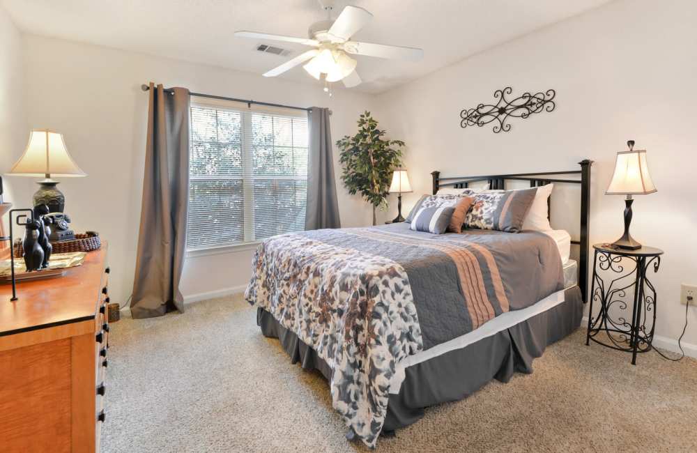 Carpeted bedroom with window and ceiling fan at Carrington Point in Douglasville, Georgia