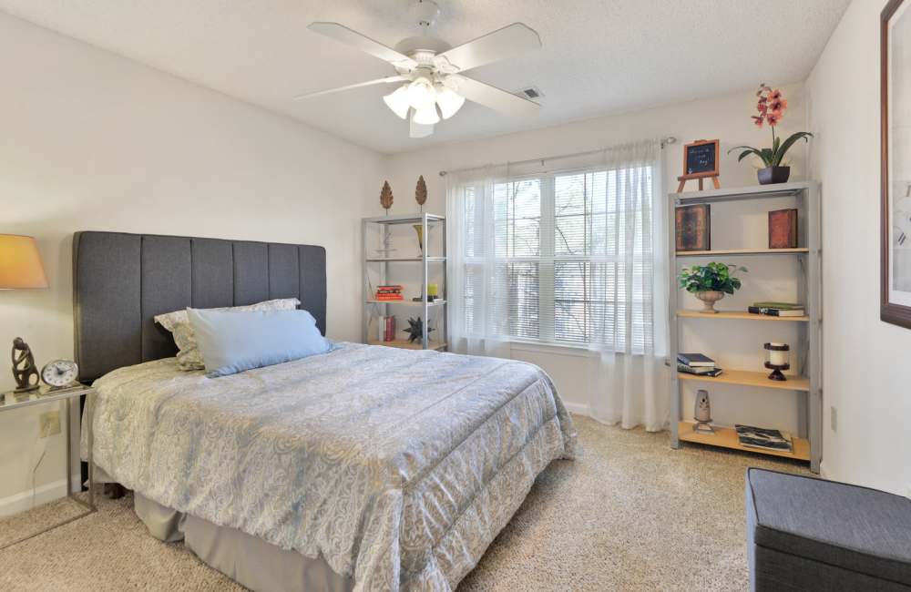 Full size bed with sunlit window at Carrington Point in Douglasville, Georgia