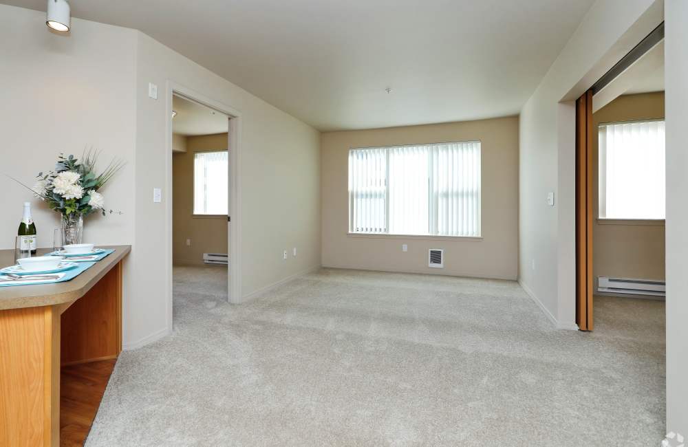 Open layout carpeted living room with plenty of room at The Blakely in Shoreline, Washington