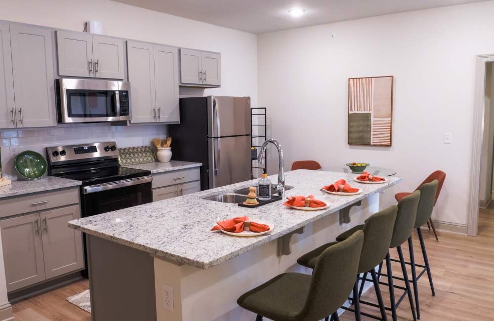 A bar island with granite countertop and bar stools at The Waters at Crestview in Crestview, Florida