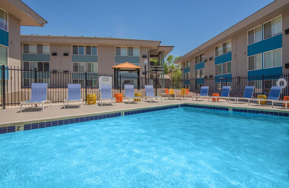 Pool with relaxing chairs at Aero Place Apartments in Colorado Springs, Colorado