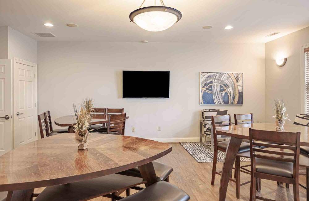 Tables and chairs in the clubhouse at Aspen Pines Apartment Homes in Wilder, Kentucky