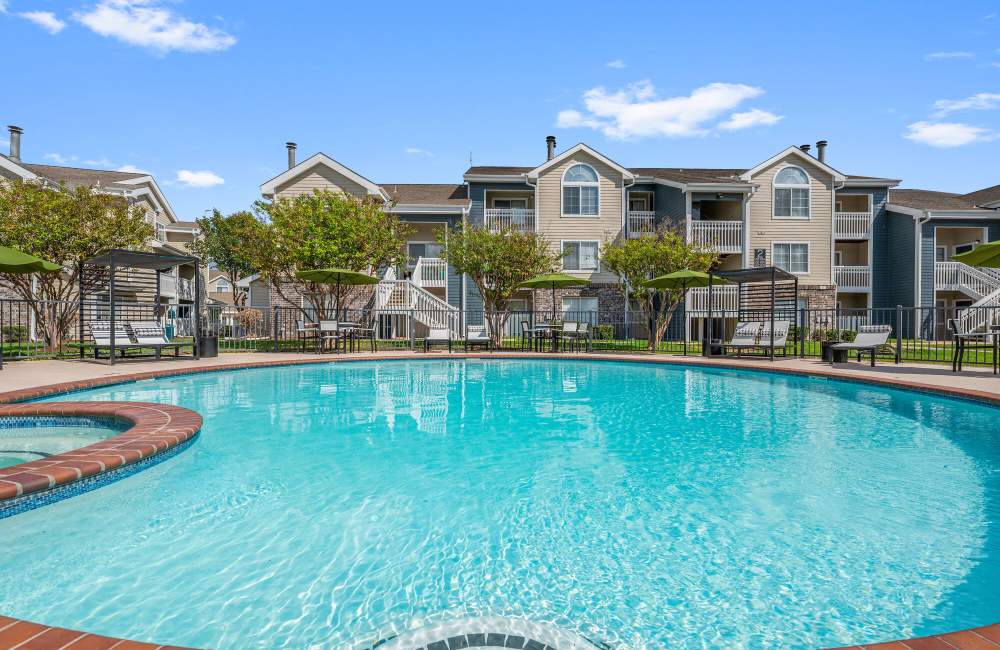 Large swimming pool with lounge beds at Park At Woodmoor Apartments in Shenandoah, Texas, 