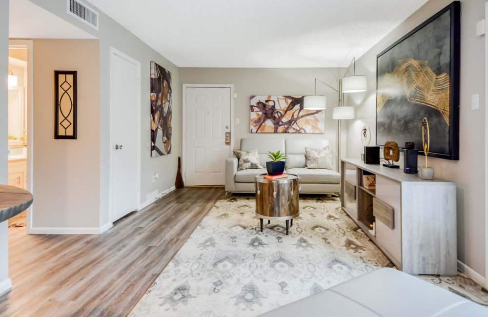 Bright living room with wood-style flooring and white accent throughout at South Shore Coastal Living in Corpus Christi, Texas, 