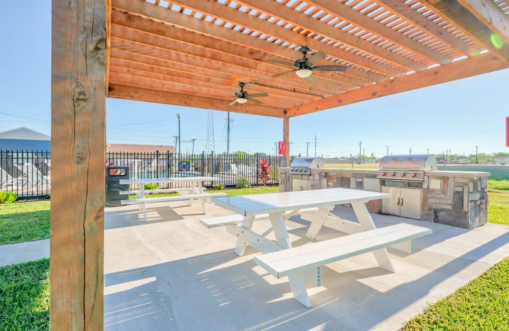 Outdoor sitting area with a couple of ceiling fans and grilling station at South Shore Coastal Living in Corpus Christi,Texas