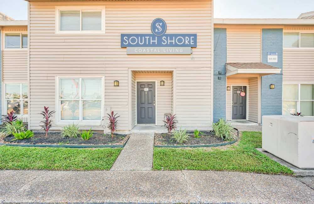 Entrance to the property with a sign board and a walkway at South Shore Coastal Living in Corpus Christi,Texas
