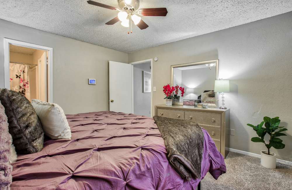 Bedroom with a ceiling fan and a comfortable bed at Woodside Flats in Dallas, Texas, 