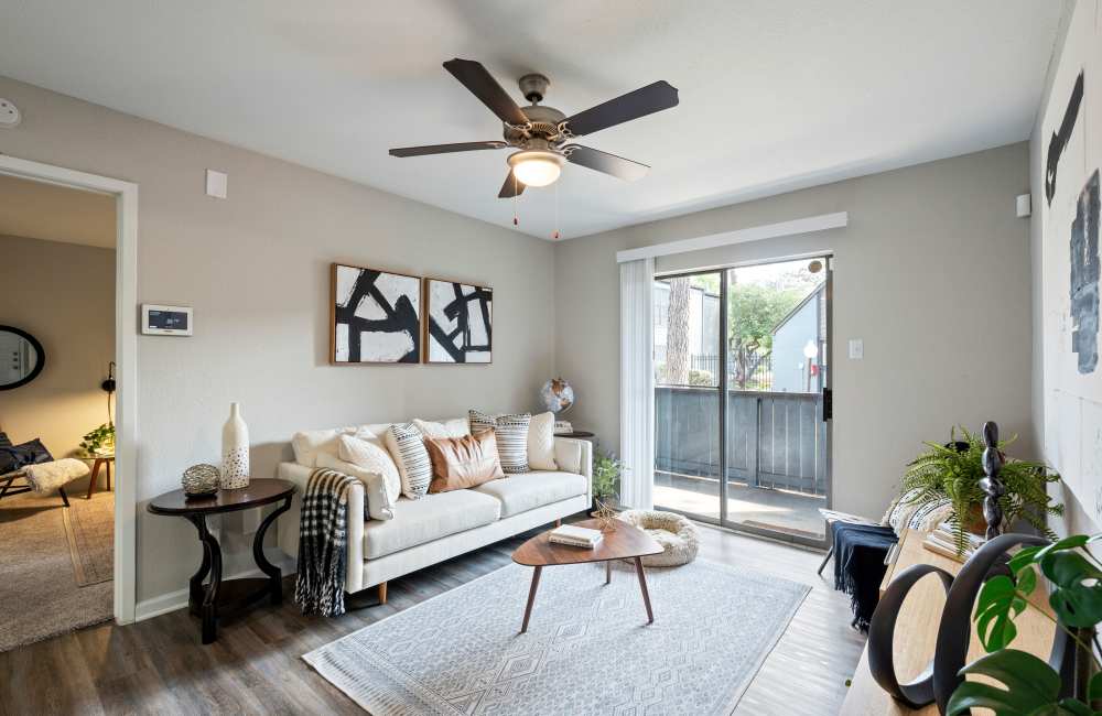 Living room with sofa and ceiling fan at North Bend Living in Houston, Texas