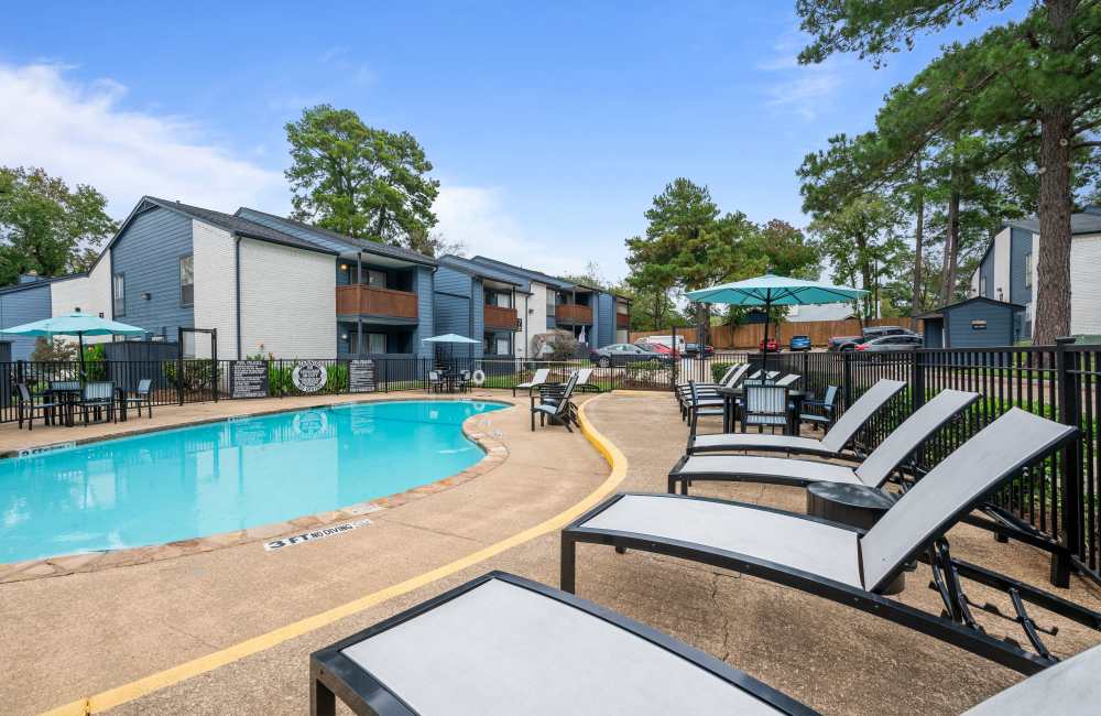 Resort-style swimming pool with multiple lounge chairs at Northside Heights in Conroe, Texas