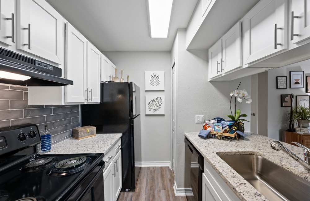 Modern kitchen with wooden cabinets and granite countertops at Northside Heights in Conroe, Texas