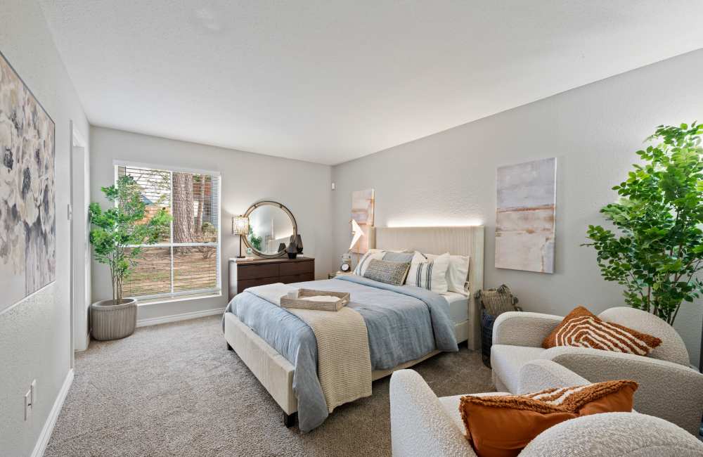 Spacious bedroom with large comfortable bed and lamp at Northside Heights in Conroe, Texas