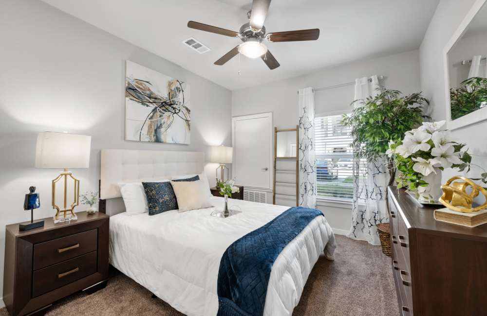 Bedroom with plush carpeting at The Tennyson at Tomball in Tomball, Texas