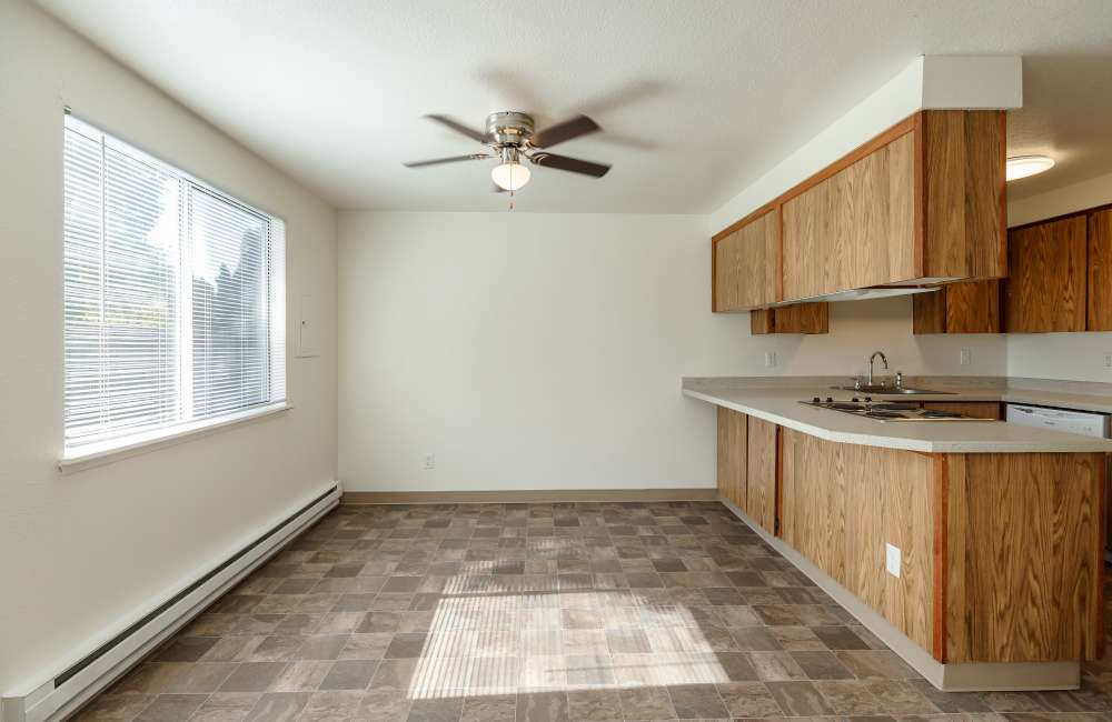 Kitchen and living room with large window at Heron Hills Apartment Homes in Gresham, Oregon