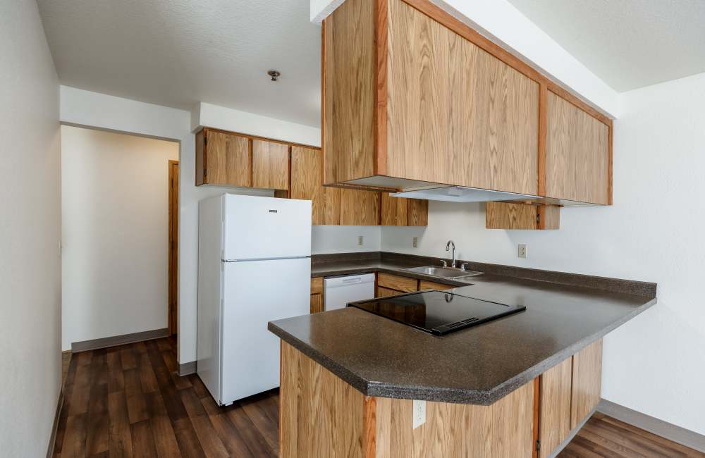 Kitchen with wood flooring at Heron Hills Apartment Homes in Gresham, Oregon