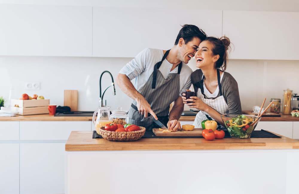 Happy couple cooking at Boomer Creek Apartments in Stillwater, Oklahoma