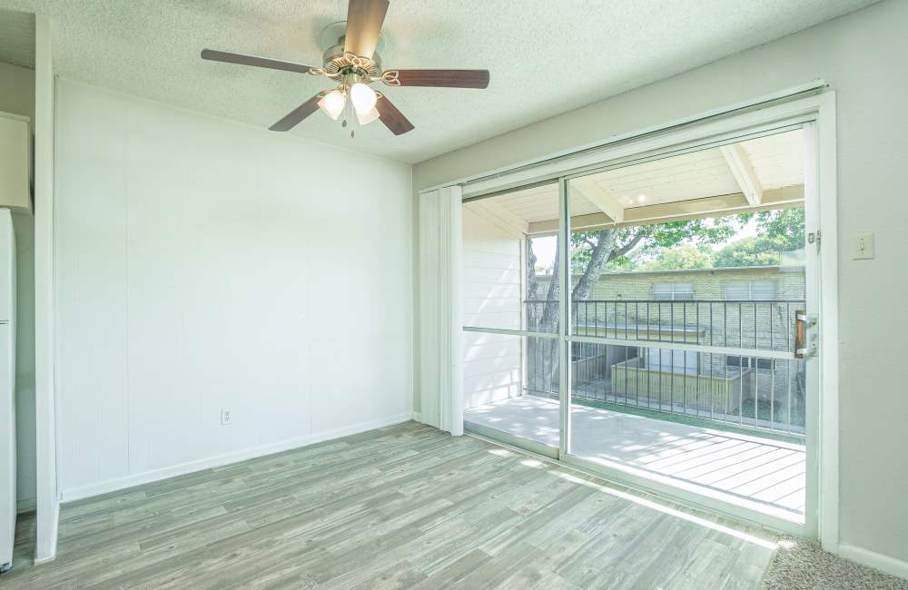 Living room with a sliding door leading to the balcony at Gold Talon in Universal City, Texas