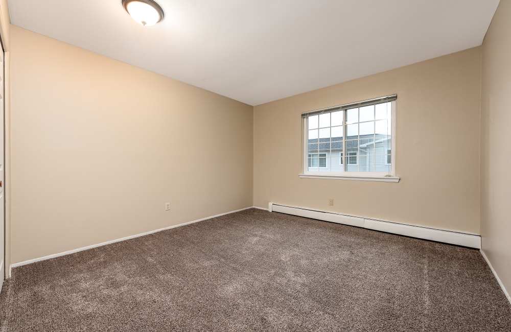 Bedroom with large windows at Birch Tree Apartments in Lansing, Michigan