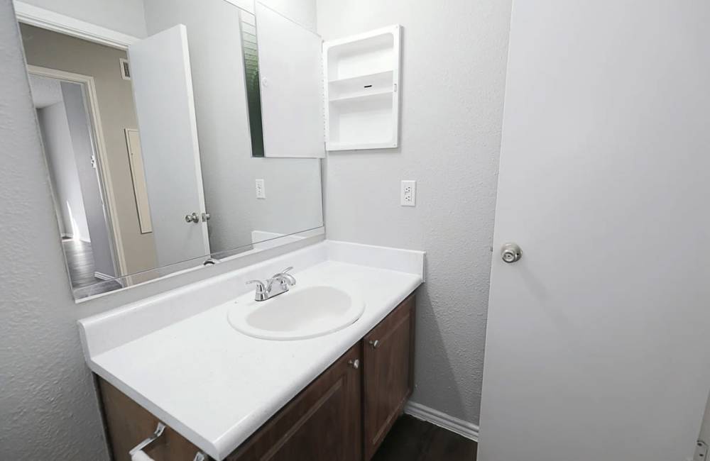 Bathroom with framless vanity mirror at Derby Park Apartments in Round Rock, Texas 