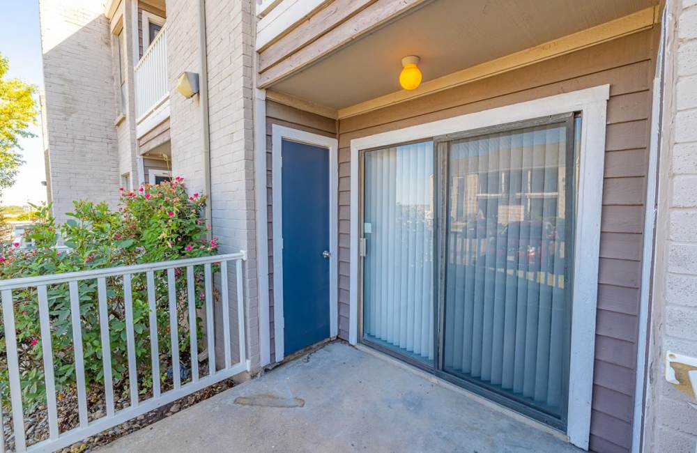 Private patio with white railing at Derby Park Apartments in Round Rock, Texas