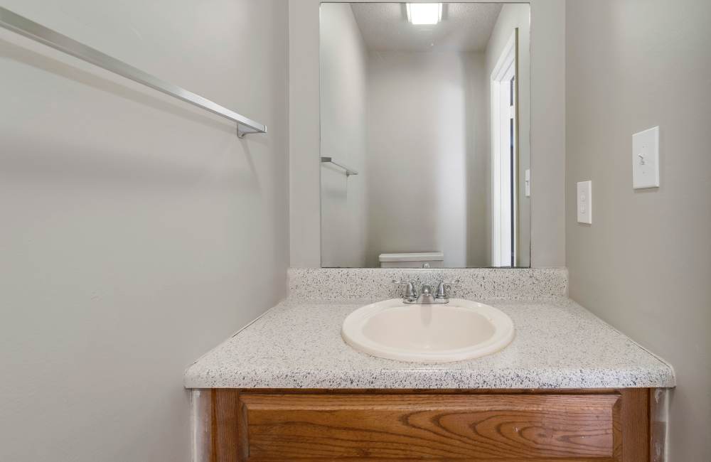 Modern bathroom with sleek countertop and large mirror at Collins Pointe in Cartersville, Georgia