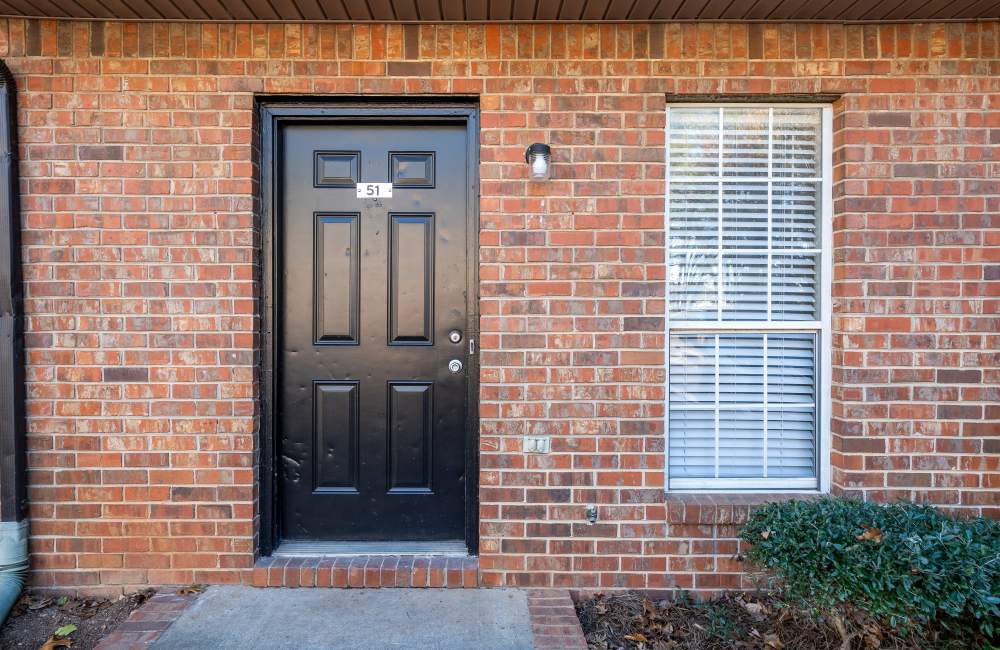 Stylish black door with brick facade and window detail at Collins Pointe in Cartersville, Georgia