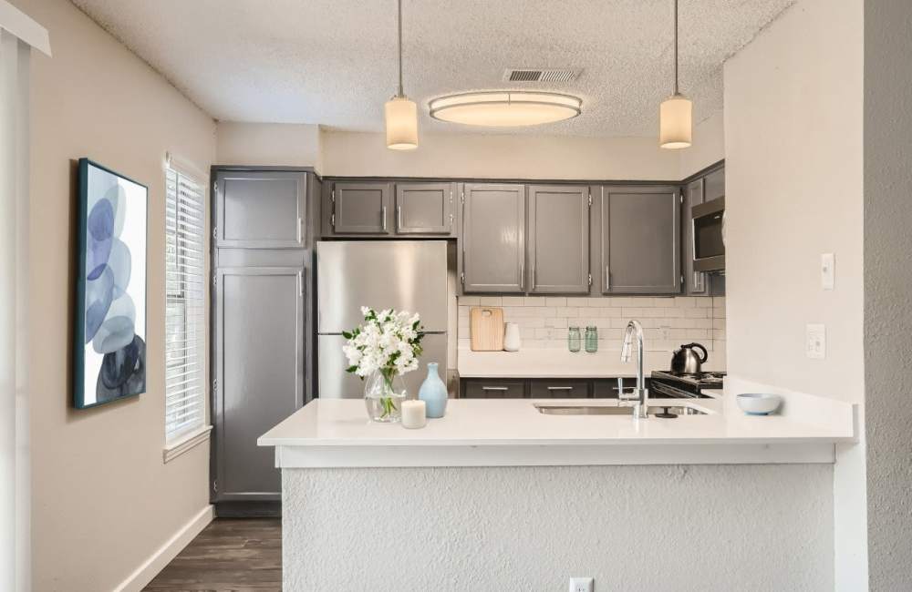 Kitchen with stainless-steel appliances and wood flooring at The Morgan in Bedford, Texas