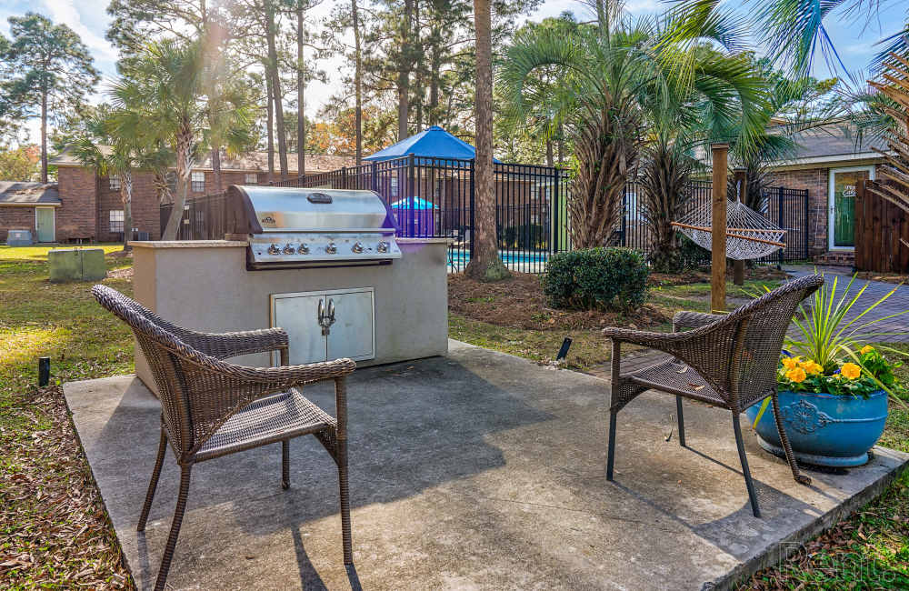 Bbq area with propane grill and seating chairs at Pine Lakes in , South Carolina