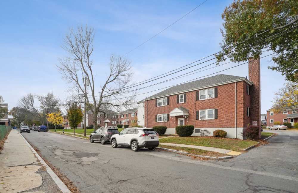 Community exterior view  with driveway at Arlington Gardens in Arlington, Massachusetts
