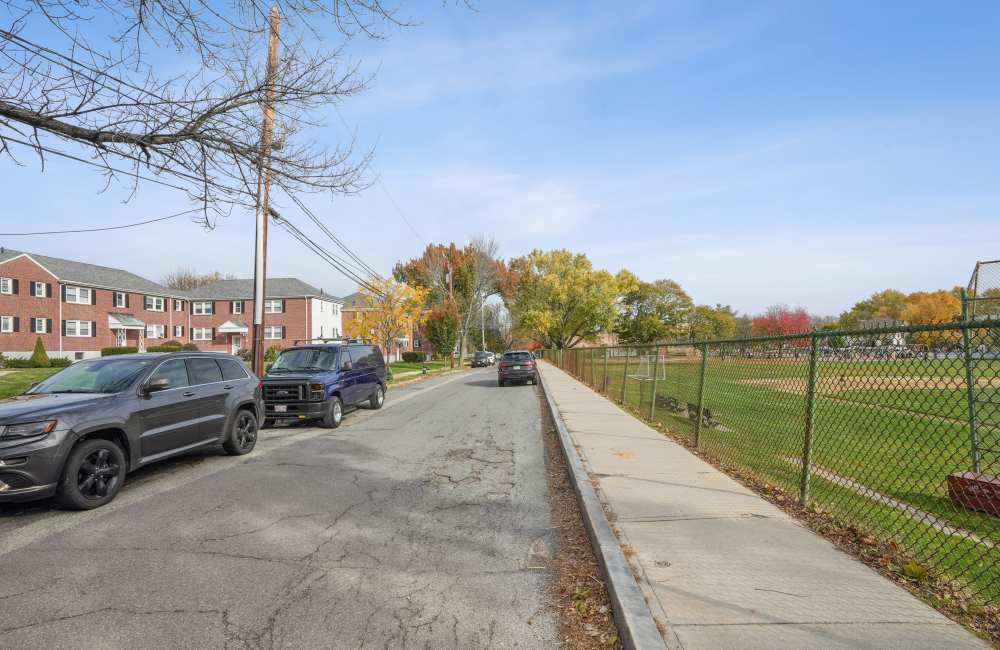 Community exterior view with car parking  at Arlington Gardens in Arlington, Massachusetts