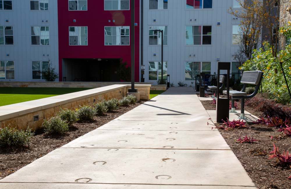 Path way to apartment with seating on side at Norman Commons in , Texas
