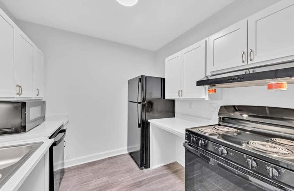 Kitchen with wooden cabinets and a dishwasher at Canebreak Apartments in Summerville, South Carolina