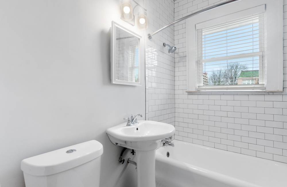 Bathroom with pedestrian sink and tub at The Alma in Memphis, Tennessee