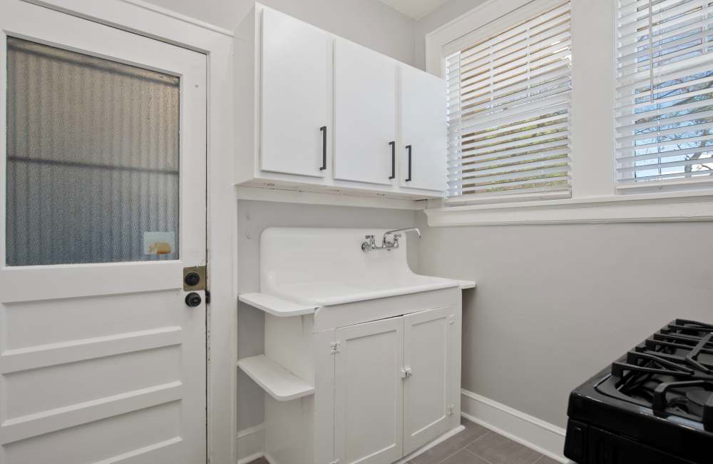 Kitchen island with dishwasher, sink with waterfall faucet, and granite countertops at The Linden in Memphis, Tennessee