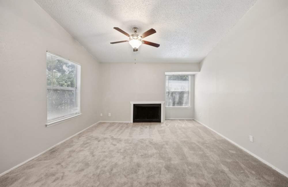 Spacious living room with fire place and ceiling fan at Sleepy Hollow in Arlington, Texas