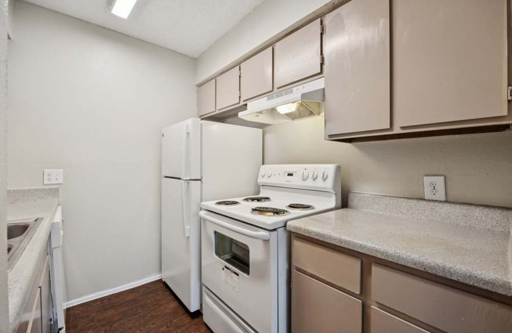 Spacious Kitchen with white appliances and white cabinets at Sleepy Hollow in Arlington, Texas